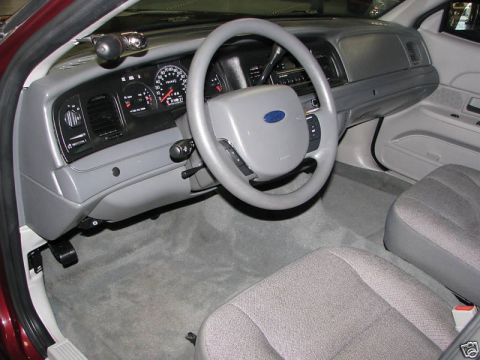2005 Ford Crown Victoria - The interior of a 2005 Ford Crown Victoria is visible, a gray dashboard and steering wheel.