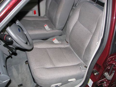 2005 Ford Crown Victoria - Front interior of a 2005 Ford Crown Victoria, cloth seats and a steering wheel.