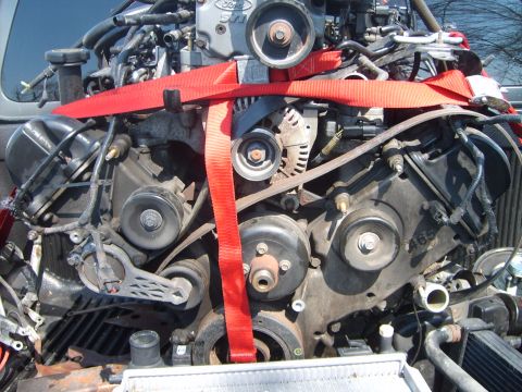 1993 Ford Crown Victoria - Engine assembly with visible belts and pulleys, secured by red straps.