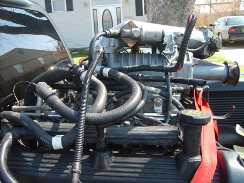 1993 Ford Crown Victoria - Close-up of an engine with a supercharger installed, showing various hoses and components.