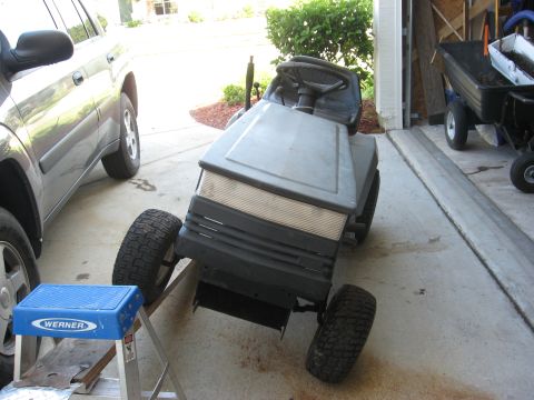 2006 Honda RANCHER - Gray lawn tractor parked in a driveway next to an SUV.