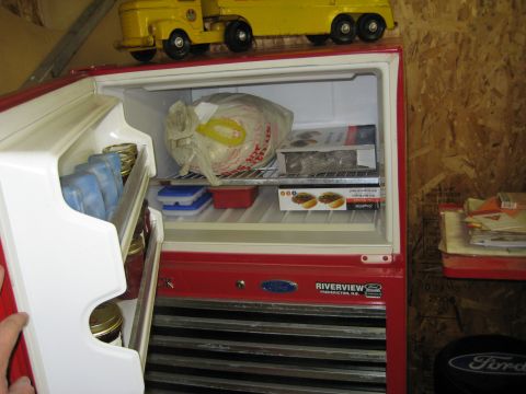 1999 Ford Crown Victoria - Contents of a red refrigerator, including food items and a toy truck on top.