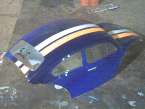 1989 Ford Bronco - A blue Volkswagen Beetle body shell with racing stripes sits on a floor.