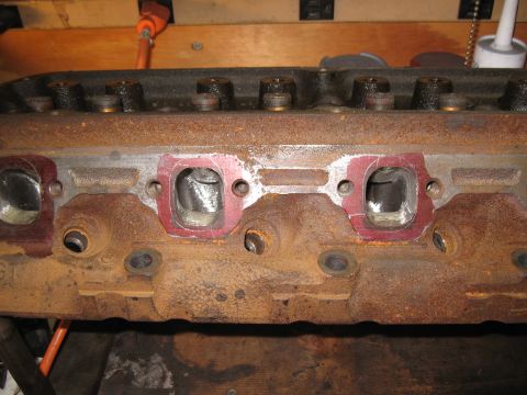 1994 Ford Bronco - Close-up of a heavily rusted engine cylinder head, showing intake and exhaust ports.