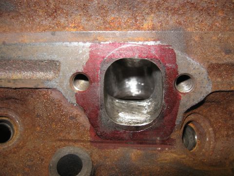 1994 Ford Bronco - This is a close-up view of a port on a heavily rusted engine block, with red sealant applied around the opening.