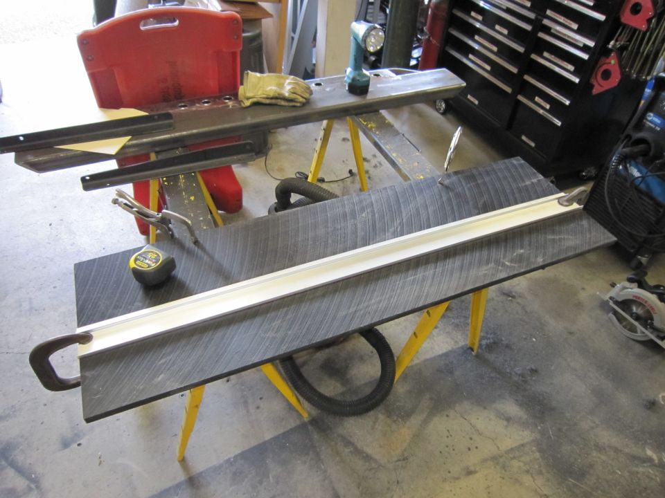 Workbench with clamps, tape measure, gloves, and a drill