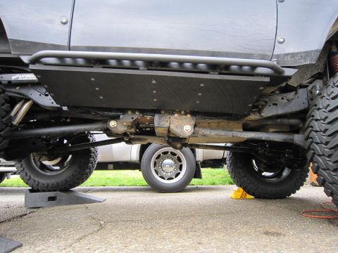 1996 Ford Bronco - The underside of a modified off-road vehicle shows heavy-duty suspension and protective plating.