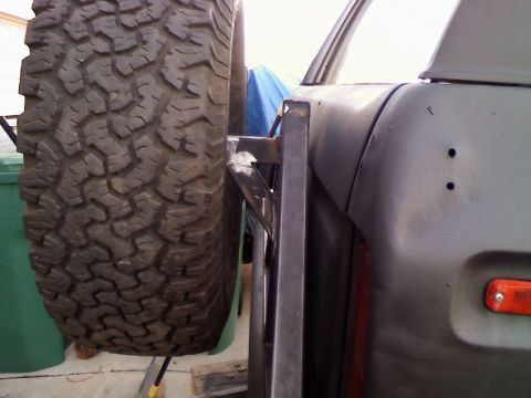1979 Ford Bronco - Custom spare tire carrier on the rear of a 1979 Ford Bronco, showing the quarter panel and taillight assembly.