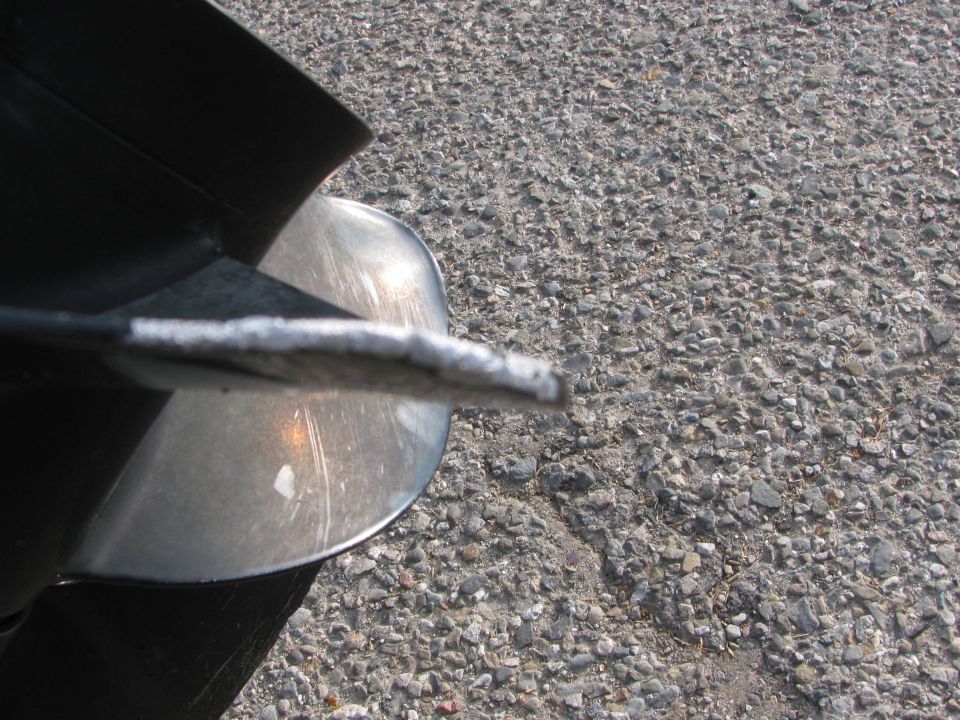 Close-up of a boat propeller on asphalt