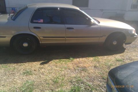 2000 Mercury Grand Marquis - A tan 2000 Mercury Grand Marquis sedan is parked outdoors on a grassy area.