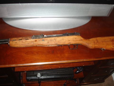 1989 Ford Bronco - A rifle with a wooden stock and metal components is displayed on a wooden surface.