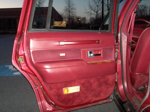 1993 Lincoln Town Car - Interior door panel detail of a red car, with visible text on a window sticker.