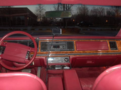 1993 Lincoln Town Car - The interior of a 1993 Lincoln Town Car features red upholstery and wood grain accents on the dashboard.