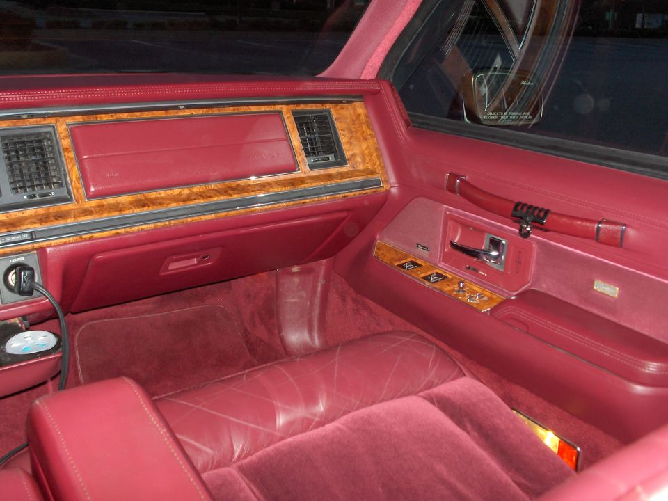 1993 Lincoln Town Car interior with red velour seats and wood trim dashboard