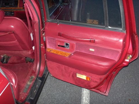 1993 Lincoln Town Car - Interior view of a red car, focusing on the door panel and seating area.