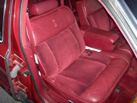 1993 Lincoln Town Car - The plush interior of a 1993 Lincoln Town Car features red velour seats with a diamond pattern and leather accents.