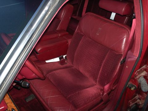 1993 Lincoln Town Car - The interior of a 1993 Lincoln Town Car features red velour seats and leather accents.