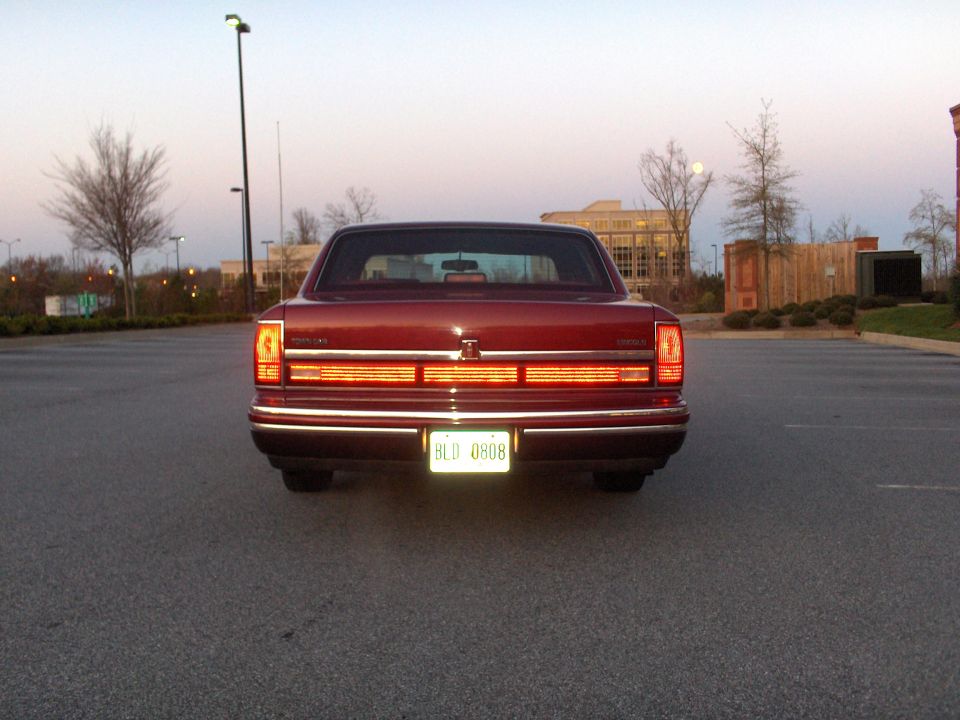 Rear view of a red 1993 Lincoln Town Car parked in a lot
