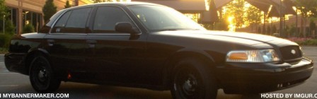 2001 Ford Crown Victoria - A black 2001 Ford Crown Victoria is parked in a lot as the sun sets behind it.