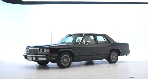 1971 Ford Ranchero - This dark sedan, likely from the 1980s, is shown from a 3/4 front angle against a white background.