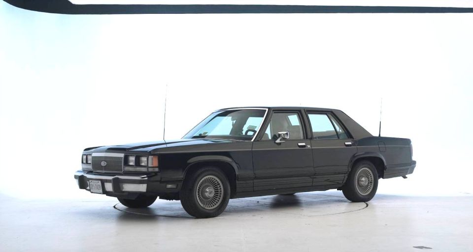 Dark sedan, 3/4 front view, circa 1980s