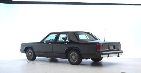 1971 Ford Ranchero - A black sedan is shown from the rear quarter angle against a plain white backdrop.