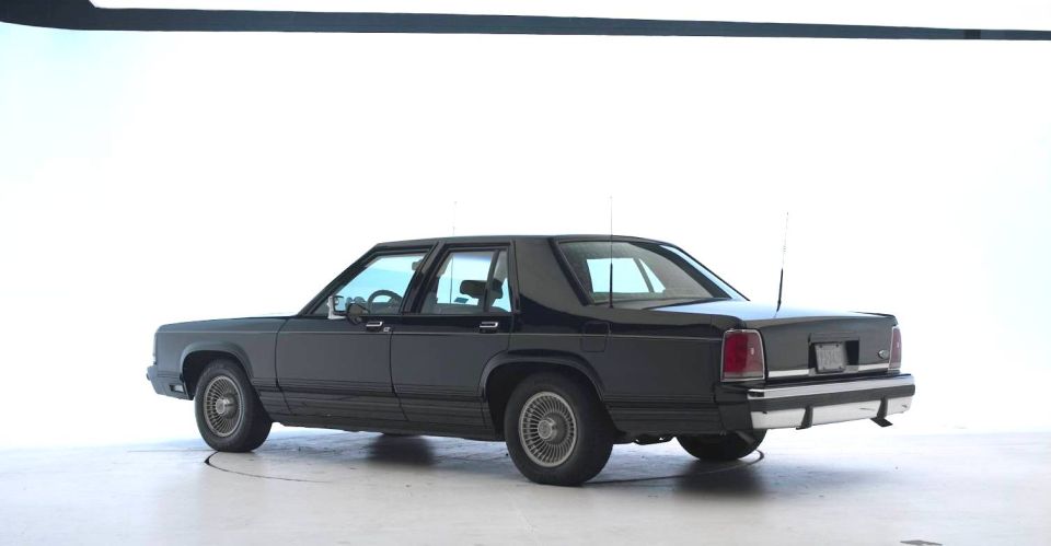 Black sedan, rear 3/4 view, white background. Supermotors.net logo in corner