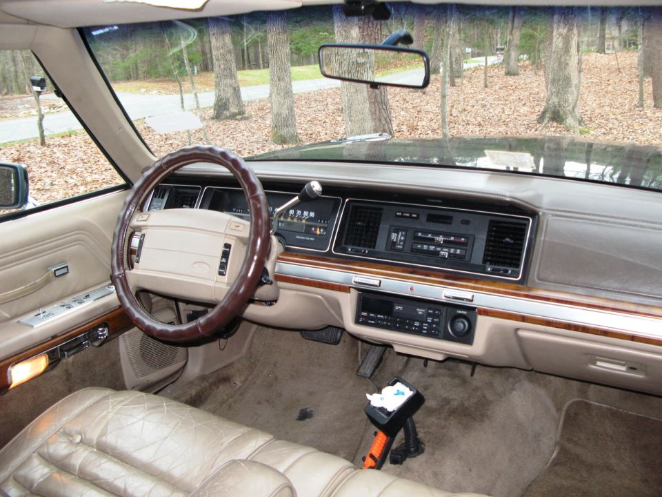 Tan leather interior of a 1991 Ford Crown Victoria, showing the dashboard, steering wheel, and seats