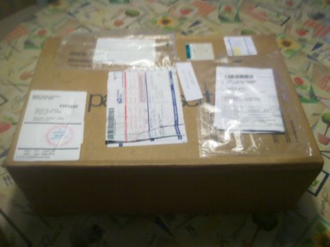1986 Ford Bronco - A cardboard box with multiple shipping labels is shown on a table.