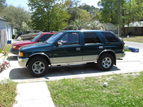 1993 Isuzu Rodeo - A two-tone Isuzu Rodeo is parked in a driveway next to another vehicle.