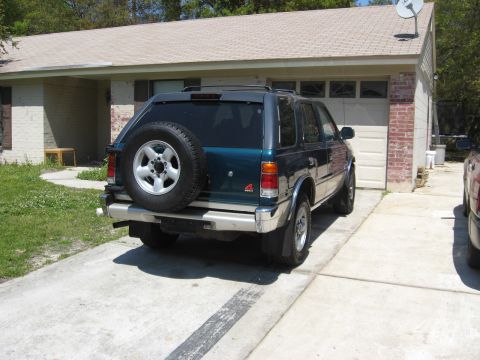1993 Isuzu Rodeo - This SUV, likely from the early 1990s, is parked in a suburban driveway.