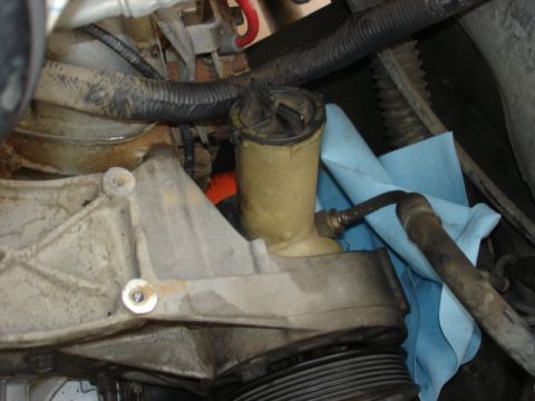 1992 Ford Bronco - This is a close-up view of the power steering fluid reservoir and associated plumbing within a vehicle's engine bay.