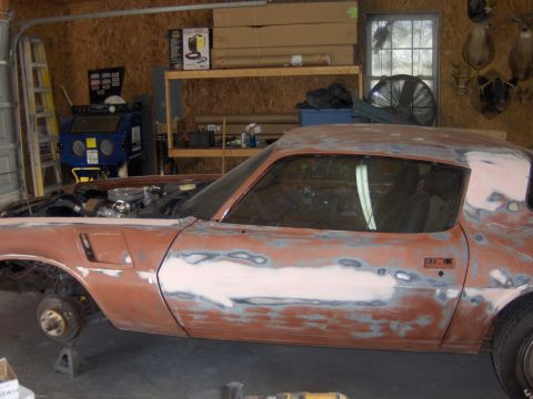 1980 Chevrolet Camaro - This car is in a garage, with its hood up and wheels removed, showing extensive bodywork in progress.