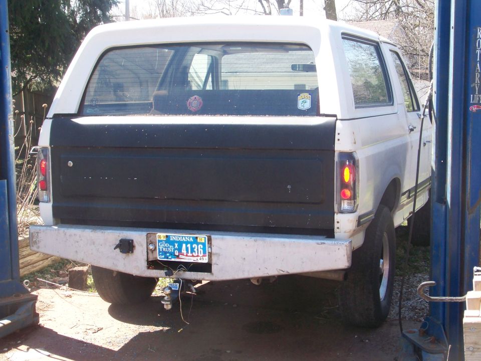 Rear of white Dodge truck/SUV on a two-post shop lift