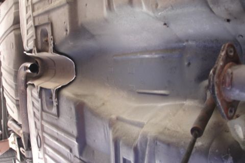 1989 Ford Taurus - The underside of a vehicle is visible, including parts of the exhaust system and frame.