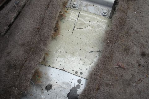 1989 Ford Taurus - Close-up of a car's interior floor, revealing worn carpet and damaged sealant.