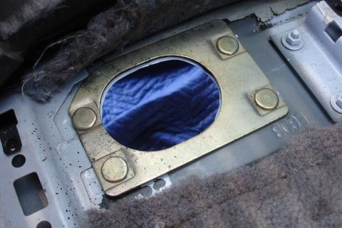 1989 Ford Taurus - Interior view of a vehicle's floor showing a metal bracket and surrounding components.
