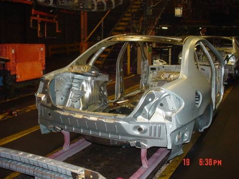 1999 Ford Crown Victoria - Unfinished car body chassis on a factory assembly line, awaiting further manufacturing processes.