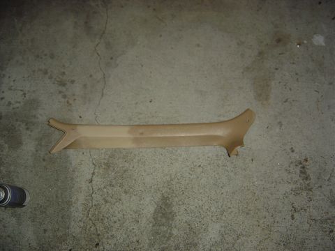 1986 Ford Bronco - A tan interior trim piece lies on a concrete floor, likely awaiting installation or restoration.