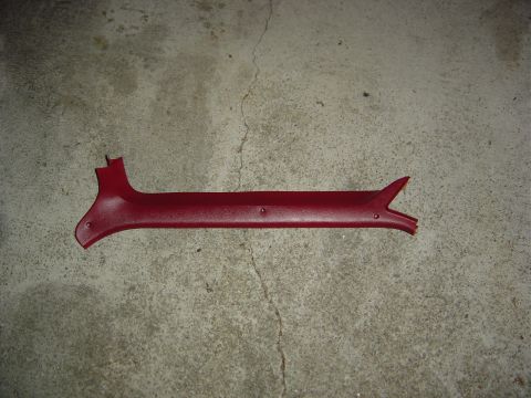 1986 Ford Bronco - A red plastic trim piece is shown against a concrete background.