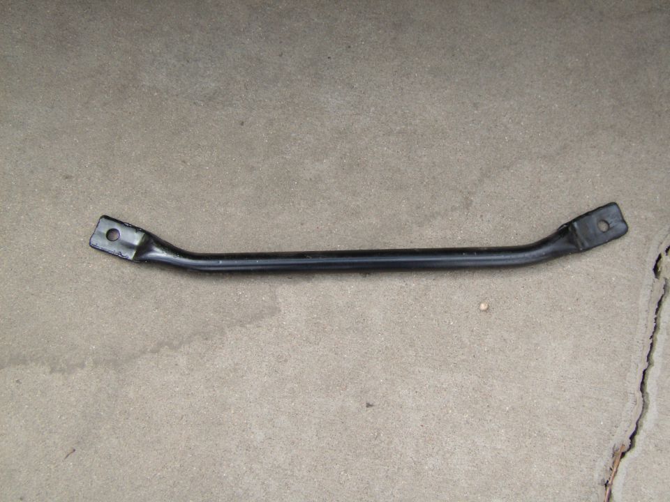 Black metal support brace with bolt holes at each end on concrete