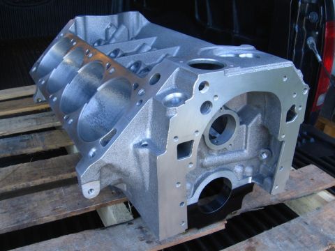 1972 Ford Ranchero - Bare aluminum V8 engine block sitting upside-down on a wooden pallet in a pickup bed, showing the honed cylinder bores, main bearing bulkhe…
