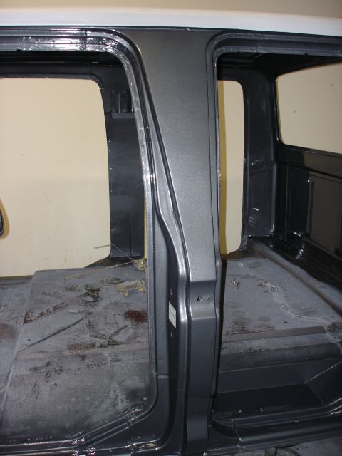 1979 Ford F-250 - The bare interior of a truck cab, with exposed floor panels and door frames, is shown in this image.