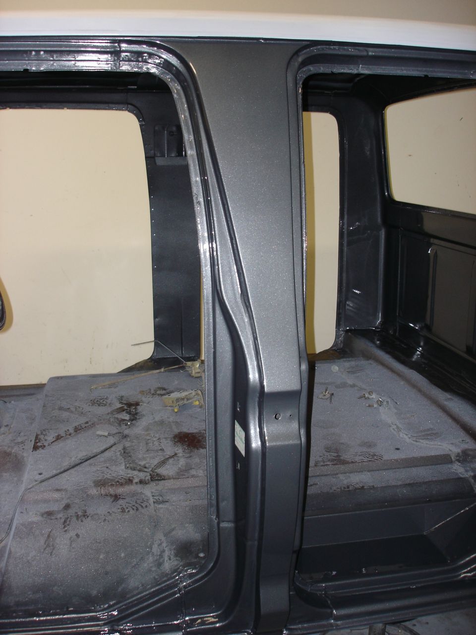 Interior of a truck cab, showing the door frames and floor area. The interior is bare, suggesting it's undergoing restoration or modification