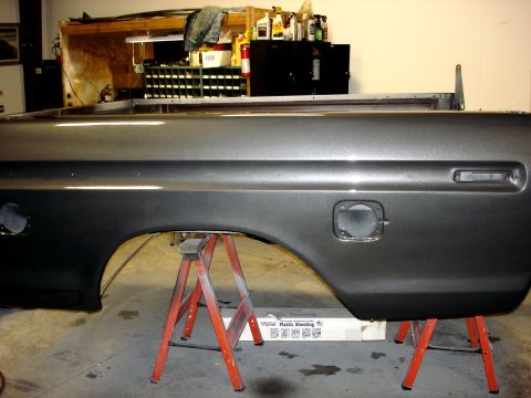 1979 Ford F-250 - A gray truck bed side panel is supported by red sawhorses in a workshop environment.