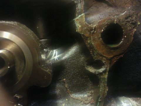 1995 Ford Bronco - Close-up of a damaged engine block part, showing a handwritten 'V4' marking.