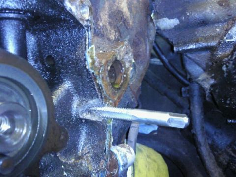 1995 Ford Bronco - A tap tool is used to thread a hole in a heavily corroded engine block.