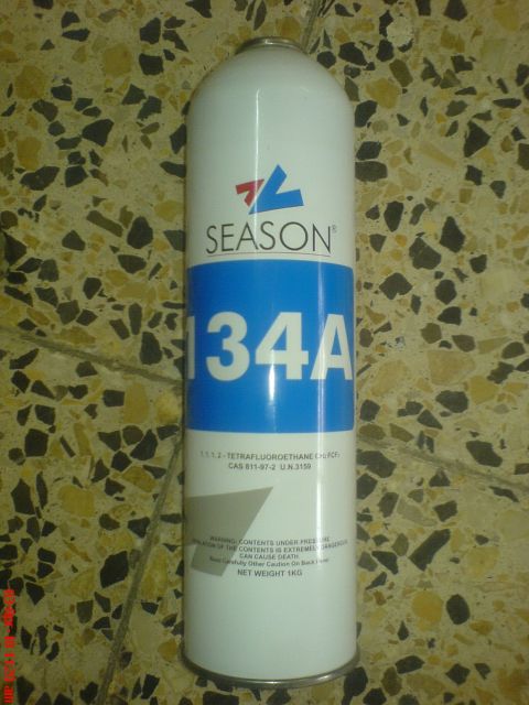1998 Ford Crown Victoria - A sealed white 1 kg can of Season brand R-134a refrigerant stands upright on a terrazzo tile floor, with a blue label band reading 134A and…