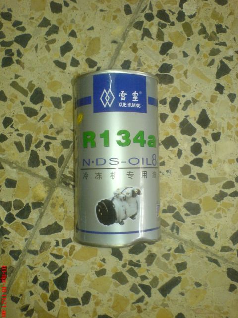 1998 Ford Crown Victoria - A silver metal can of Xue Huang R134a "N-DS-OIL 8" refrigerant compressor oil standing on a speckled terrazzo tile floor, its blue-and-silv…