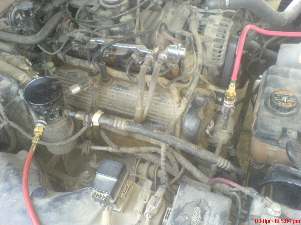 Interior of a car, showing a dark green seat and dashboard area. Some parts are disassembled